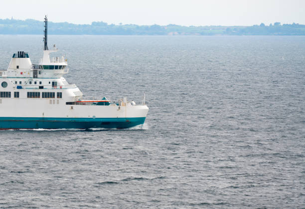 A white passenger and car Ferry sailing at sea.