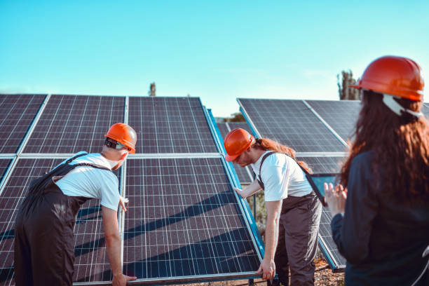 istock Workers Positioning New Solar Panel According To Female's Drawings On Digital Tablet 1406951010