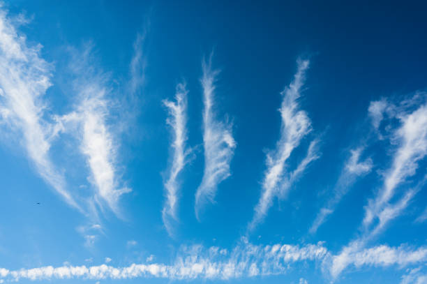 istock An unusual celestial landscape with white clouds. White puffy clouds in the form of rays spread out from the horizon. A lonely bird flies to the left of the frame 1406952177