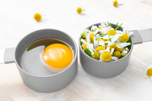 Ingredient for natural homemade cosmetics. Egg and chamomile for hair care