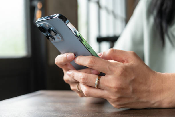 Hands woman using Iphone 13pro playing social media stock photo