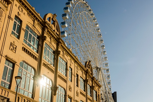 Rio de Janeiro, Brazil. Facade of an old building in the port and in the background the ferris wheel in a late afternoon. Background blue sky.