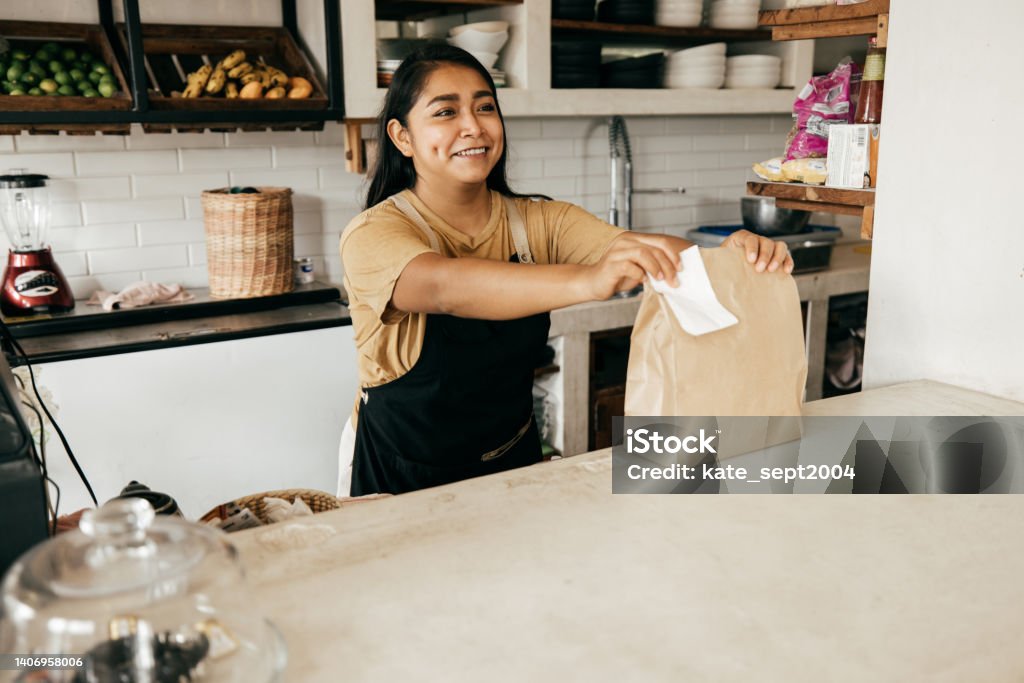 How to survive a recession: A guide for making the most of your money during a difficult time Young woman at work Serving Food and Drinks Stock Photo