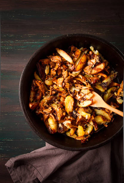 istock Fried chanterelles with mushrooms, in a clay pan, close-up, top view, selective focus, 1406967110