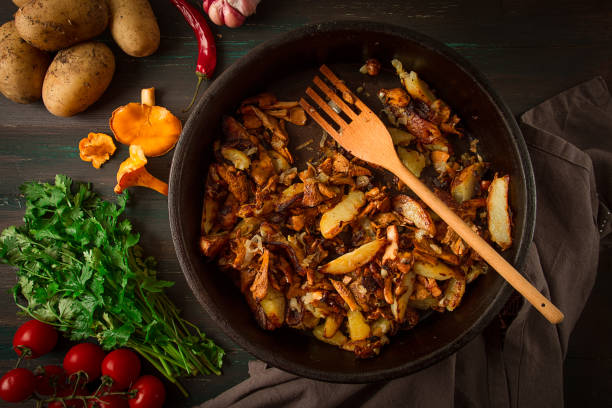 istock Fried chanterelles with mushrooms, in a clay pan, close-up, top view, selective focus, 1406967111