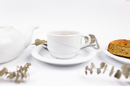 a white tea set with teapot tea and saucers and pie for breakfast