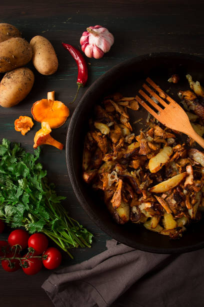 istock Fried chanterelles with mushrooms, in a clay pan, close-up, top view, selective focus, 1406968335