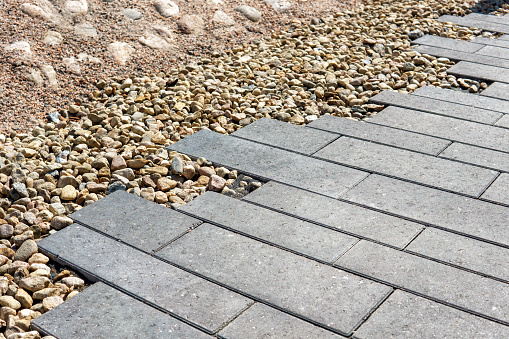 New home yard paving bordered by a gravel area with rocks.