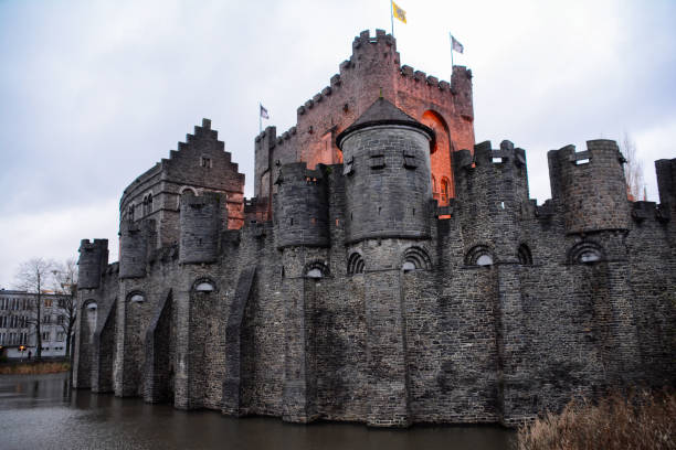 Antwerp, Belgium, September 22, 2024: Het Steen medieval fortress, stone castle with towers and Lange Wapper Statue on bank of Scheldt river in Antwerp city historical centre, Antwerpen old town