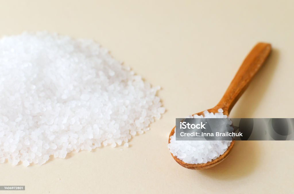 A handful of white sea salt with a wooden spoon. Rough texture. Salt is suitable for cooking and beauty treatments. Horizontal orientation. Alternative Therapy Stock Photo