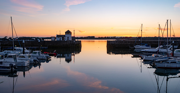 Dock Office of the harbour of Caernarfon, Wales, during sunset and the island of Anglesey in the background