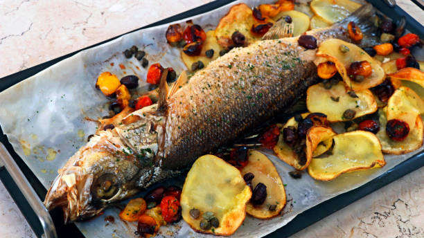 mediterranean style cooking, oven baked whole atlantic sea bass fish on a dish - sea bass prepared fish food grilled imagens e fotografias de stock