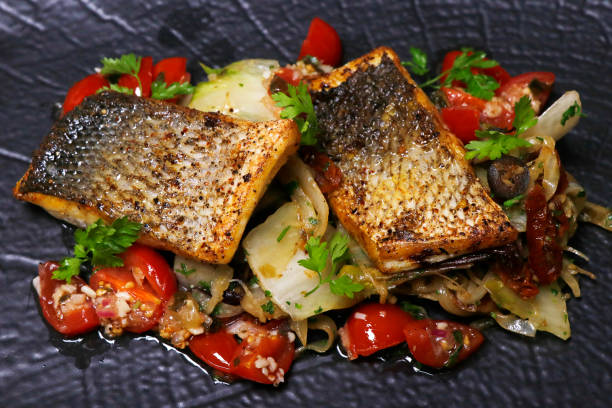 филе белой рыбы, обжаренное на сковороде, приготовление в средиземноморском стиле - sea bass prepared fish food grilled стоковые фото и изображения