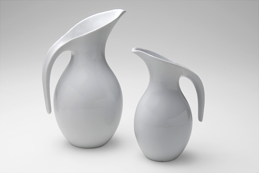 Two modern white ceramic jars, of different sizes, isolated on white