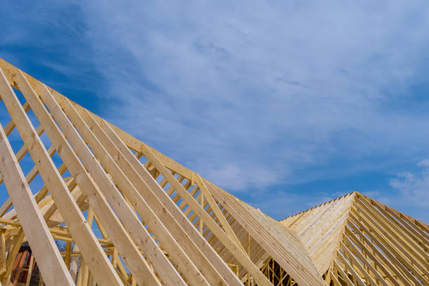 Low angle of unfinished dwelling house garret with wooden roof trusses and red brick walls