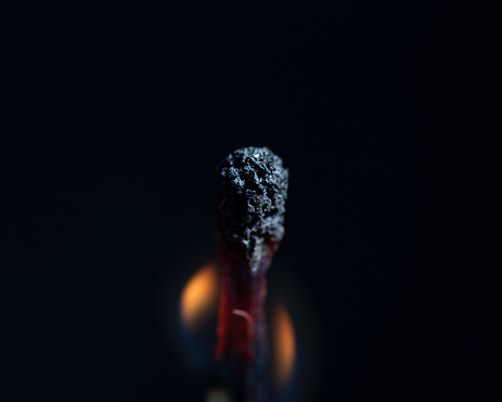 Two matchsticks burning side by side, black background. close-up.