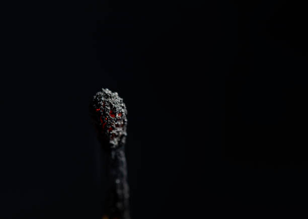 Standing, burning match on a black background