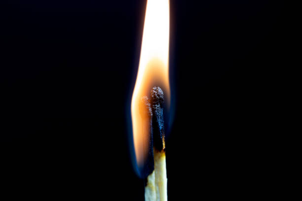 Two matchsticks burning side by side, black background. close-up. stock photo