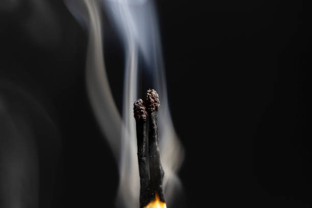 istock smoking matchsticks. close-up, black background. 1406983786