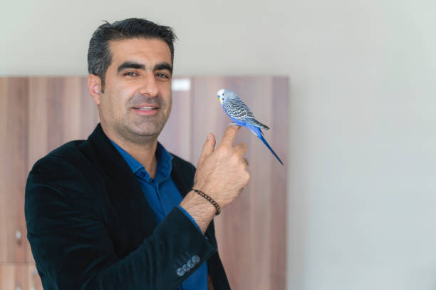 istock Officer in a suit and a budgie perched on his finger 1406984359