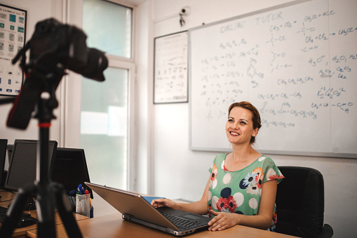 Portrait of a young female teacher holding online class