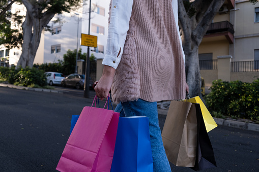 woman walking shopping with colored paper bags