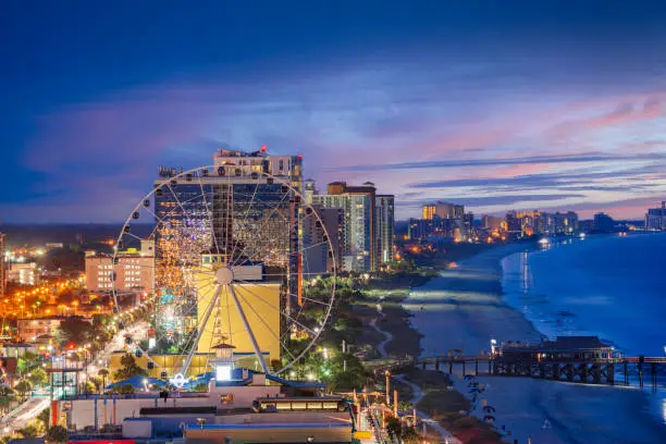 Myrtle Beach, South Carolina, USA city skyline on the beach at dusk.