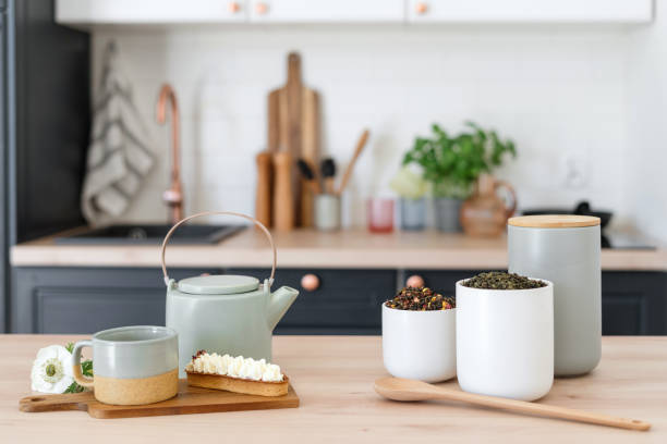 tè di ceylon, bollitore ed éclair sul tavolo in cucina - lavender mint tea foto e immagini stock