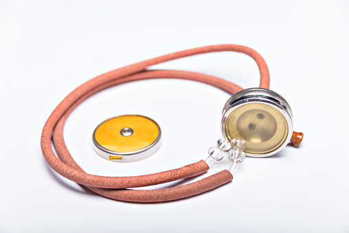 Old red stethoscope on isolated white background