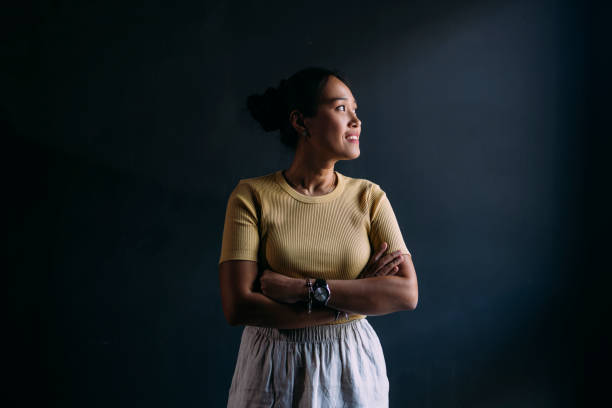 A Beautiful Happy Woman With Arms Folded Standing Against Isolated Grey Background