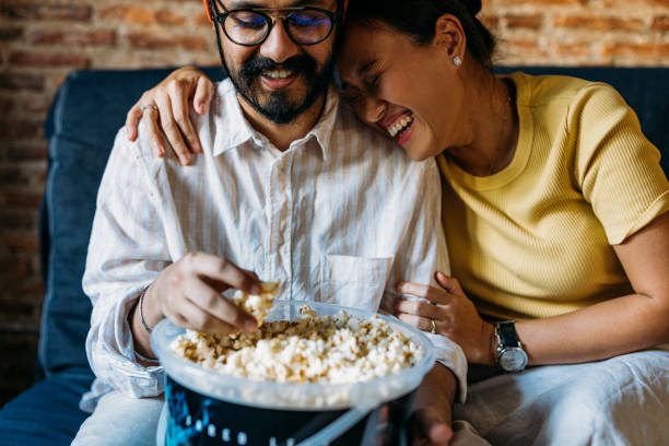 istock A Happy Mixed-race Couple Enjoying Eating Popcorn While Relaxing At Home 1406993022