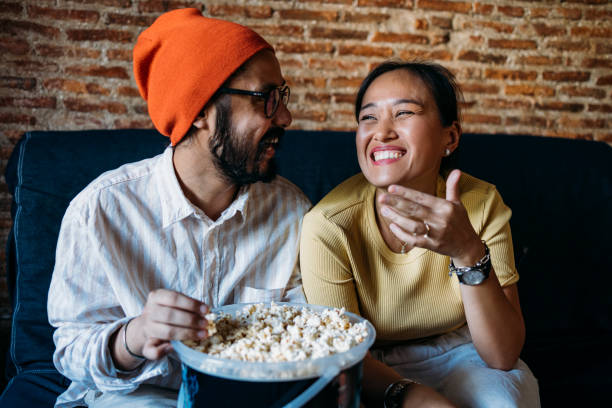 istock A Happy Mixed-race Couple Enjoying Eating Popcorn While Relaxing At Home 1406993026