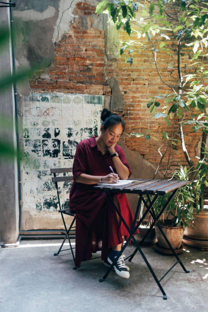 istock A Smiling Student Sitting At The Cafe And Studying 1406993061