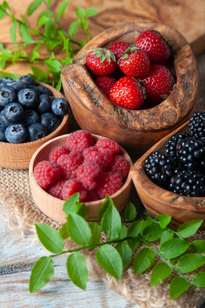 istock Colorful berries assortment on rustic wooden table 1406993494
