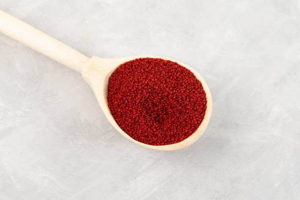 istock Beetroot couscous in wooden spoon, close-up. Red color couscous. Grey background, copy space 1406994292