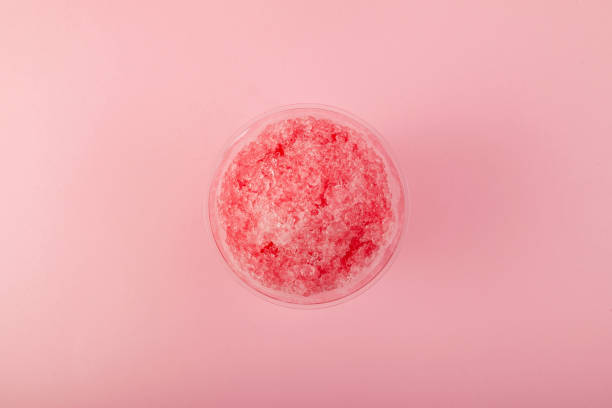 istock Fruit shaved ice or italian ice in disposable plastic cup on pink background, close-up, top view. Slushie - drink. Refreshing summer drink 1406994410