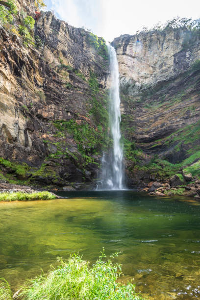 istock Beautiful view to big wild green waterfall and rocky wall 1406994901