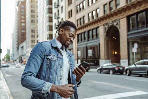 istock Confident African-American young man using mobile phone on the street 1406995894