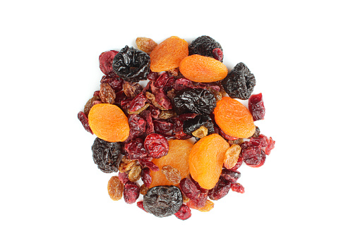 Mixture of dry candied fruits isolated on white background. Prunes, dry apricots, raisins and cranberries