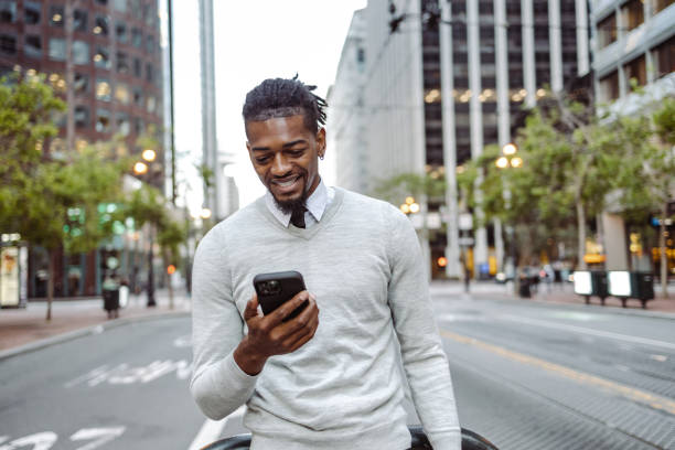 istock African-American man using smart phone and walking 1406996131