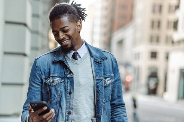 istock Confident African-American young man using mobile phone on the street 1406996285
