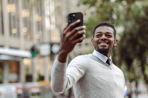 istock Cheerful smart casual man using mobile phone for video call communication 1406996993