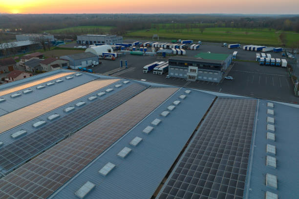 vista aerea della centrale solare con pannelli fotovoltaici blu montati sul tetto di un edificio industriale per la produzione di elettricità ecologica verde. produzione di un concetto di energia sostenibile - musica industrial foto e immagini stock
