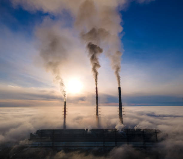 usina de carvão tubos altos com fumaça preta movendo-se para cima atmosfera poluente. produção de energia elétrica com conceito de combustível fóssil - rasto de fumo de avião - fotografias e filmes do acervo