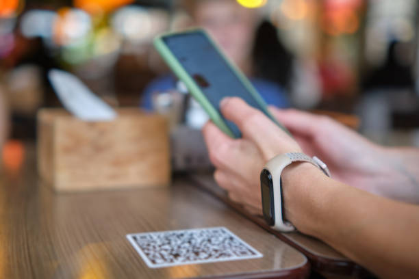 istock Closeup of guest hand ordering meal in restaurant while scanning qr code with mobile phone for online menu. 1406997358