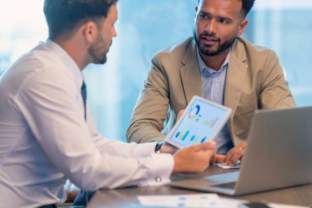 istock Business people working on financial data, graphs and charts on a digital tablet. 1406998228