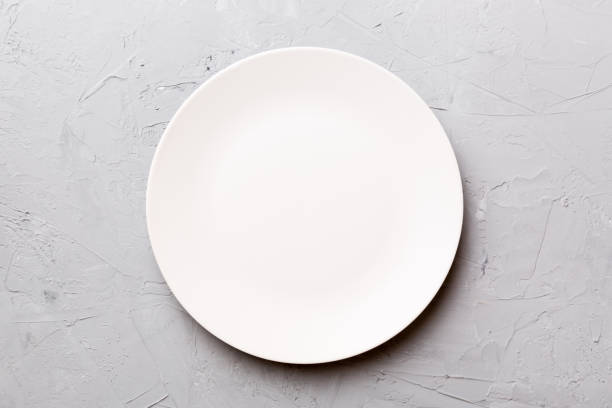 istock Top view of empty light plate on cement background. Empty space for your design 1407001435