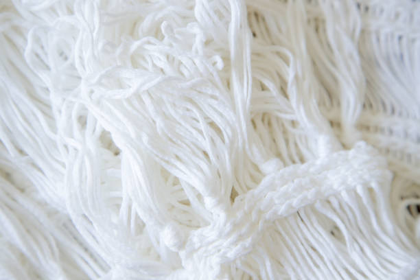 istock Background made with white knitted fabric threads making a nice and cozy texture. Abstract white image resembling a fabric. Close-up image. 1407001855