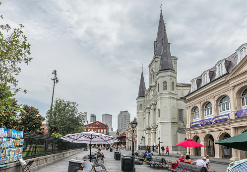 New Orleans, LA, USA - June 27, 2022: View of tourist walking around St. Louis Cathedral, in the French Quarter of New Orleans, Louisiana. St. Louis Cathedral, is the seat of the Roman Catholic Archdiocese of New Orleans and is the oldest cathedral in continuous use in the United States.