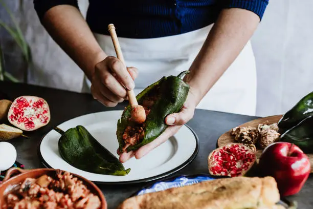 mexican woman cooking chiles en nogada recipe with Poblano chili and ingredients, traditional dish in Puebla Mexico